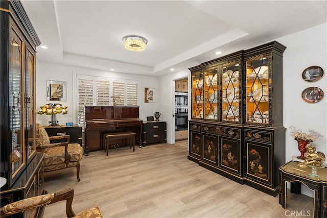 interior space featuring light hardwood / wood-style floors and a tray ceiling