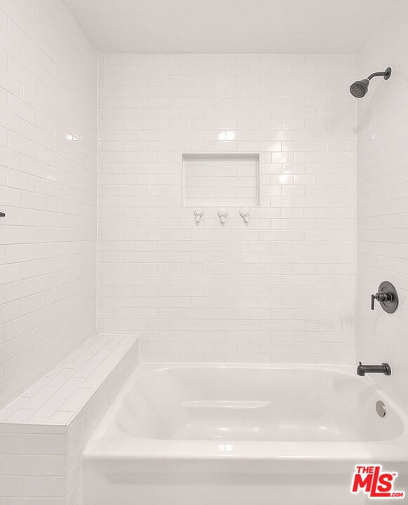 bathroom featuring tiled shower / bath