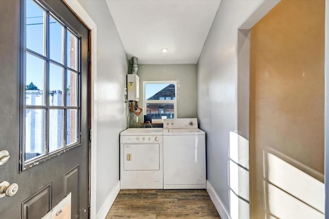 laundry room featuring independent washer and dryer, dark hardwood / wood-style floors, a wealth of natural light, and water heater