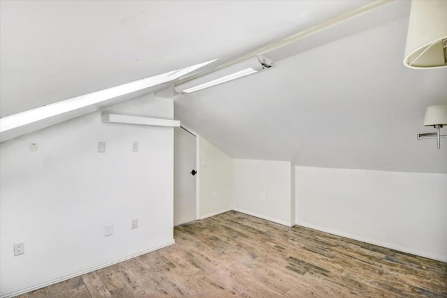 bonus room with hardwood / wood-style floors and lofted ceiling