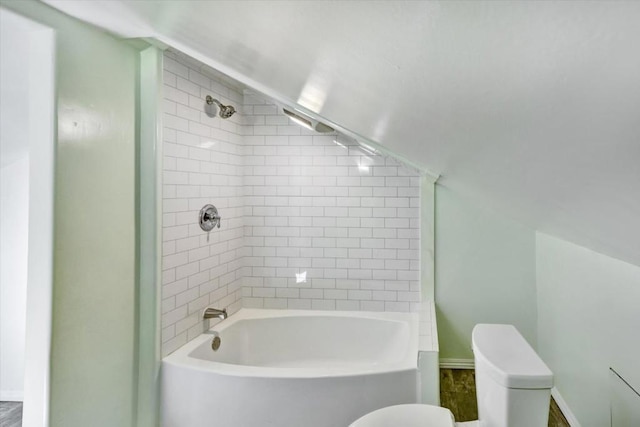 bathroom with toilet and tiled shower / bath