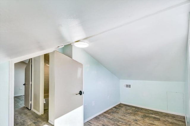 additional living space featuring lofted ceiling and dark wood-type flooring