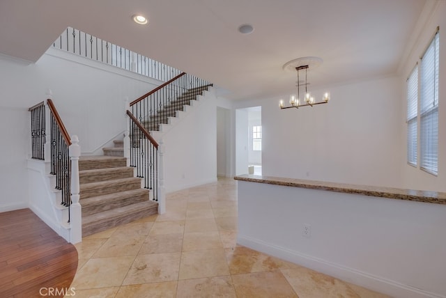 interior space featuring hardwood / wood-style floors, ornamental molding, a wealth of natural light, and a chandelier