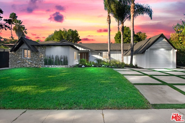 view of front of home featuring a lawn and a garage