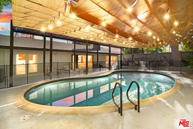 pool at dusk featuring french doors and a patio