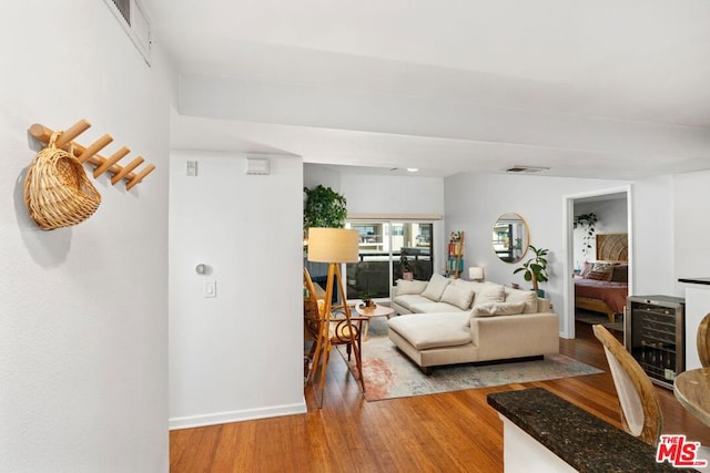 living room with beverage cooler and hardwood / wood-style flooring