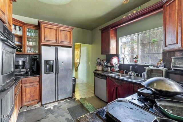 kitchen featuring decorative backsplash, light tile patterned floors, sink, and appliances with stainless steel finishes