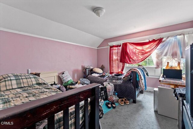 carpeted bedroom with lofted ceiling