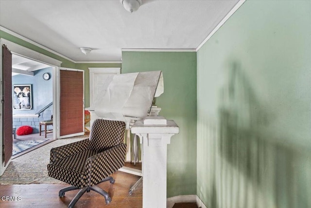 living area featuring wood-type flooring and ornamental molding