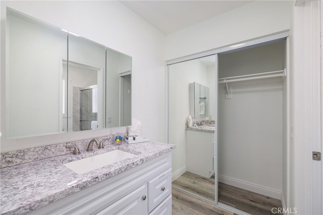 bathroom featuring hardwood / wood-style floors, vanity, and walk in shower