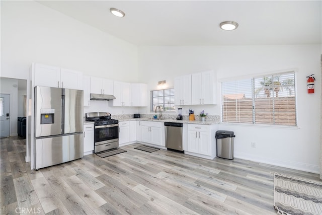 kitchen featuring stainless steel appliances, sink, high vaulted ceiling, light hardwood / wood-style flooring, and white cabinetry