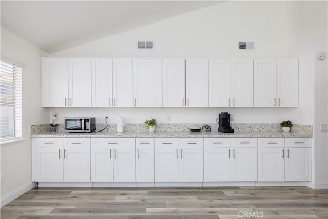 kitchen with white cabinetry and light hardwood / wood-style flooring