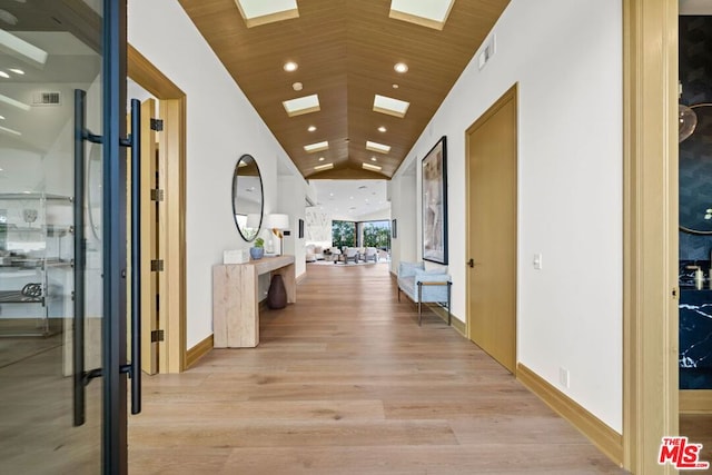 hall with light hardwood / wood-style floors, wood ceiling, and high vaulted ceiling