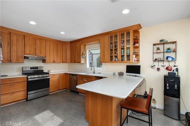 kitchen with kitchen peninsula, a kitchen bar, stainless steel appliances, and sink