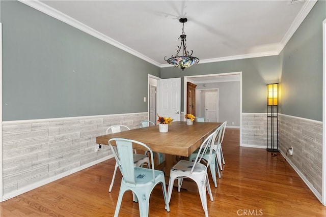 dining area with hardwood / wood-style flooring and ornamental molding