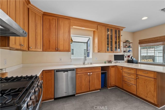 kitchen featuring tile patterned floors, sink, extractor fan, and appliances with stainless steel finishes