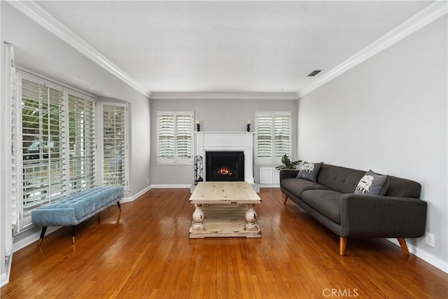 living room with hardwood / wood-style floors, crown molding, and a wealth of natural light