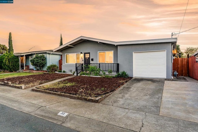 single story home featuring a porch and a garage