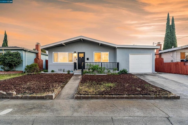 single story home featuring a porch and a garage