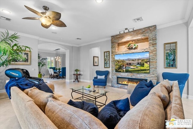 living room with crown molding, a fireplace, and ceiling fan