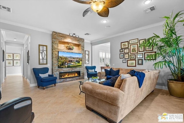 living room featuring ceiling fan, a stone fireplace, light tile patterned floors, and crown molding