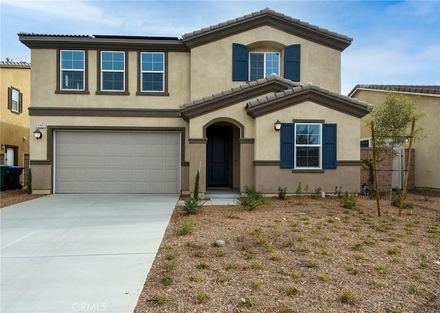 mediterranean / spanish-style house featuring concrete driveway, a tiled roof, an attached garage, and stucco siding