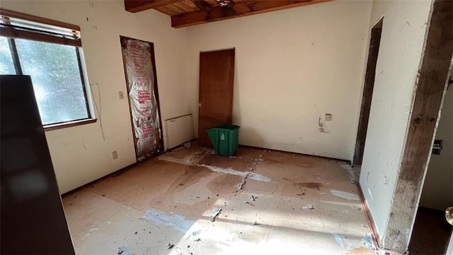 unfurnished bedroom with beam ceiling