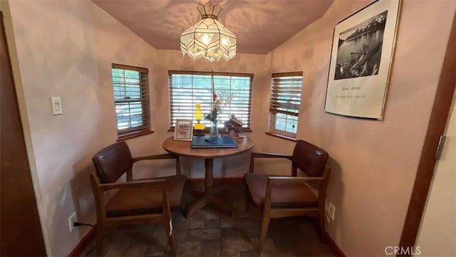 dining space featuring lofted ceiling and a notable chandelier