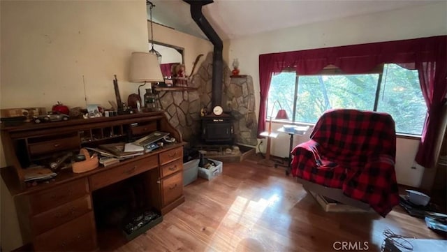 living area featuring light wood-type flooring and a wood stove