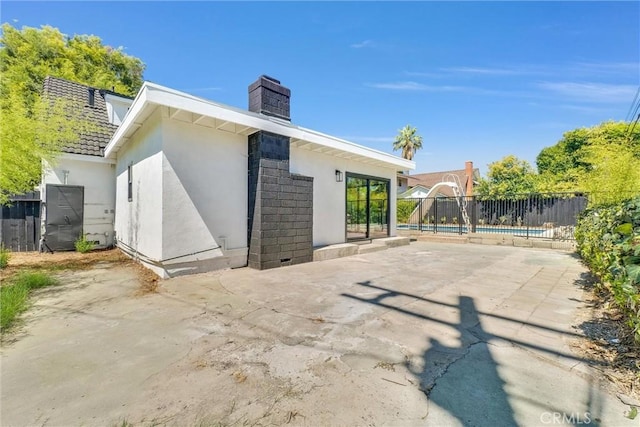 rear view of property with a patio and a swimming pool