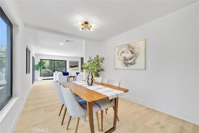 dining room featuring an inviting chandelier and light hardwood / wood-style flooring