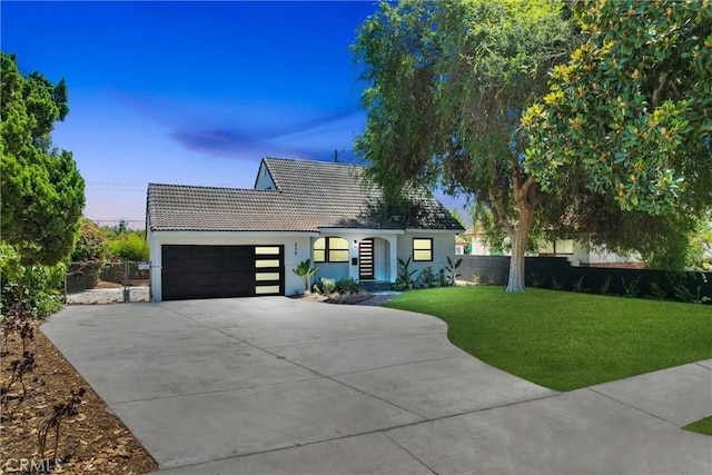 view of front of property featuring a garage and a front lawn