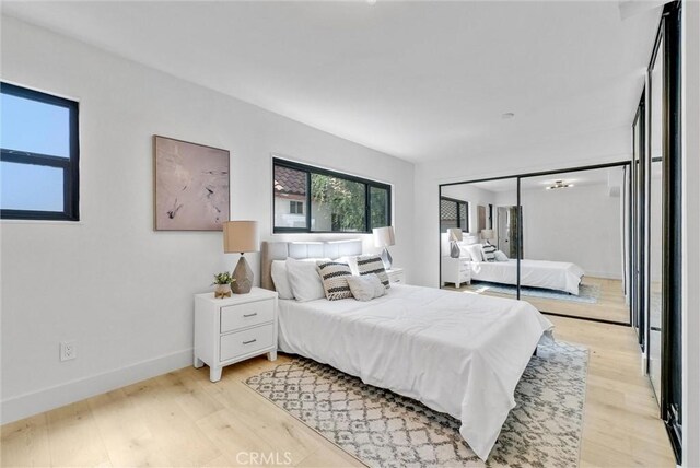 bedroom with light wood-type flooring and a closet