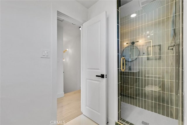 bathroom with hardwood / wood-style floors and a shower with door