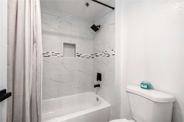 bathroom with shower / bath combination with curtain and toilet