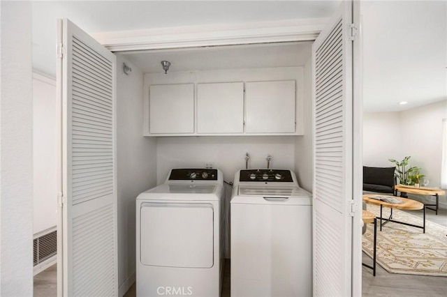 laundry area featuring cabinets and washing machine and dryer