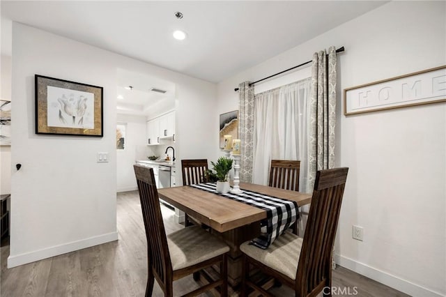 dining room featuring hardwood / wood-style floors and sink