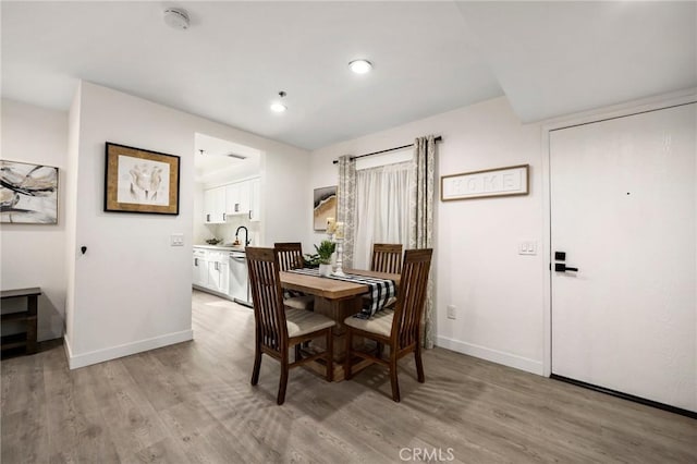 dining area with light hardwood / wood-style flooring and sink