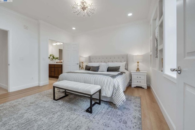 bedroom with hardwood / wood-style flooring, an inviting chandelier, ornamental molding, and ensuite bath