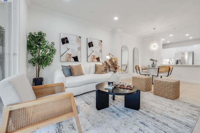 tiled living room with sink, crown molding, and a notable chandelier