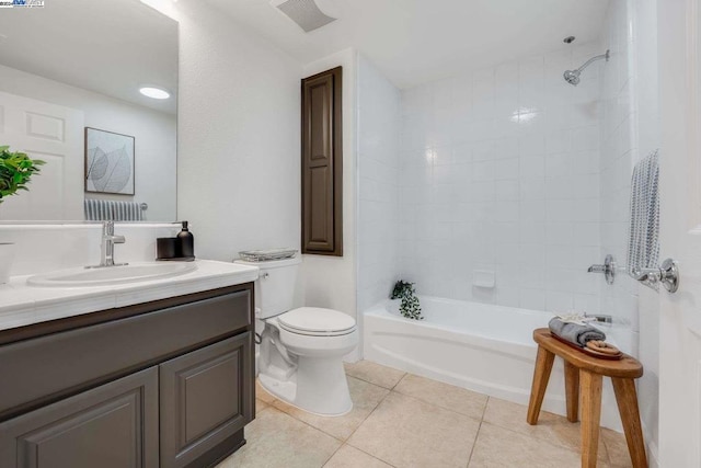 full bathroom with tile patterned floors, tiled shower / bath, vanity, and toilet