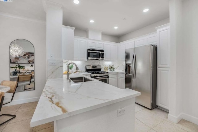 kitchen with kitchen peninsula, appliances with stainless steel finishes, white cabinetry, and sink