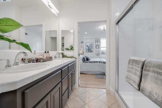 bathroom featuring tile patterned flooring, vanity, and walk in shower