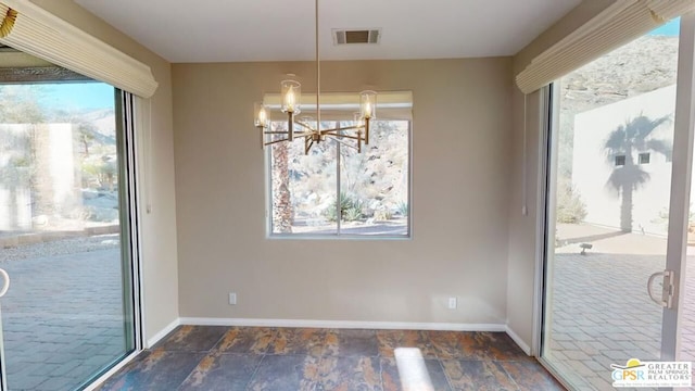 unfurnished dining area featuring a wealth of natural light and a chandelier