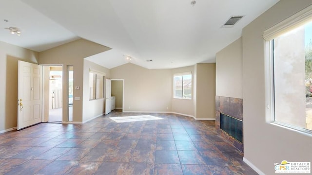 unfurnished living room with a tiled fireplace and vaulted ceiling