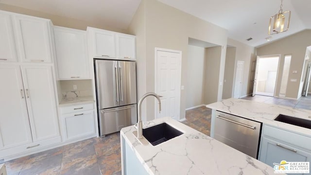 kitchen with hanging light fixtures, appliances with stainless steel finishes, sink, and white cabinets