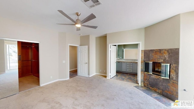 unfurnished living room featuring a fireplace, ceiling fan, and carpet