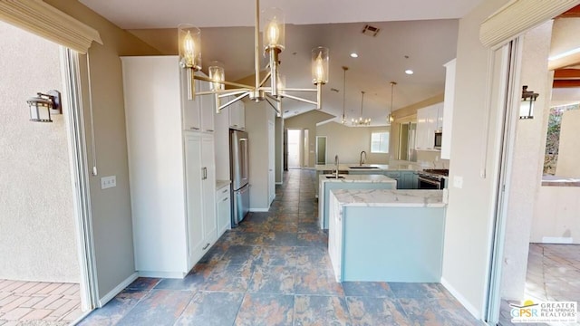 kitchen featuring sink, white cabinetry, hanging light fixtures, premium appliances, and kitchen peninsula