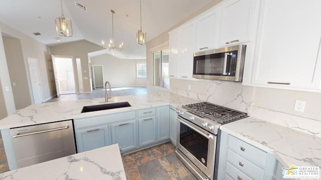 kitchen with sink, vaulted ceiling, stainless steel appliances, and hanging light fixtures