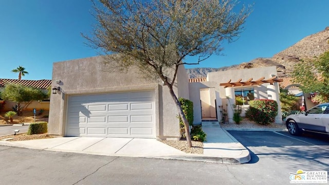 pueblo revival-style home with a garage and a mountain view